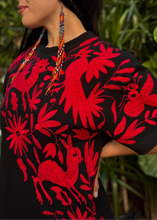 Woman wearing a black shirt with red floral patterns outdoors