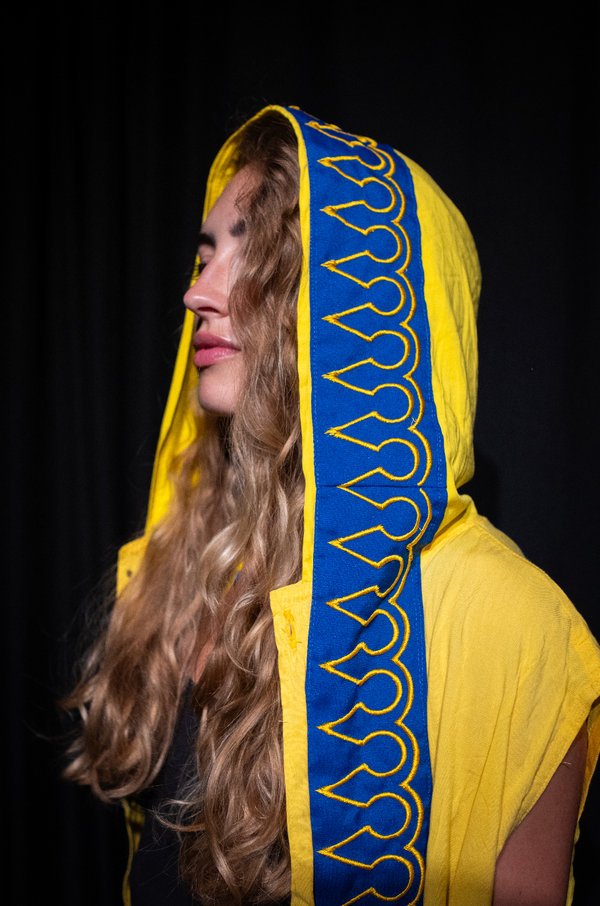 1-of-1 yellow ceremonial cloak with black-and-white serpent down the back and sacred flame embroidery on the hood, designed for ritual, dance, and spiritual leadership.